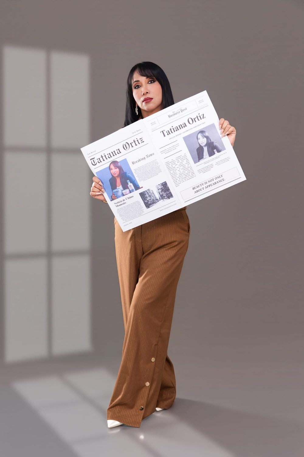 Tatiana Ortiz holding a newspaper editorial reading Beauty is not only about appearance